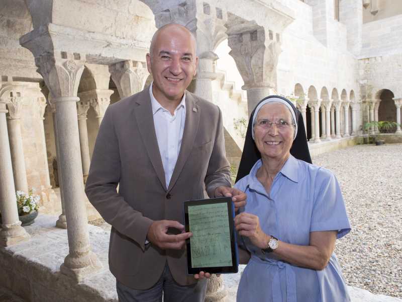 El rector, Quim Salvi, i la priora del Monestir de Sant Daniel, Maria Assumpció Pifarré, mostren un dels pergamins digitlaitzats