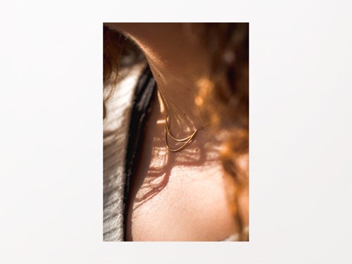 Pla detall d'un collaret daurat penjat al coll d'una noia