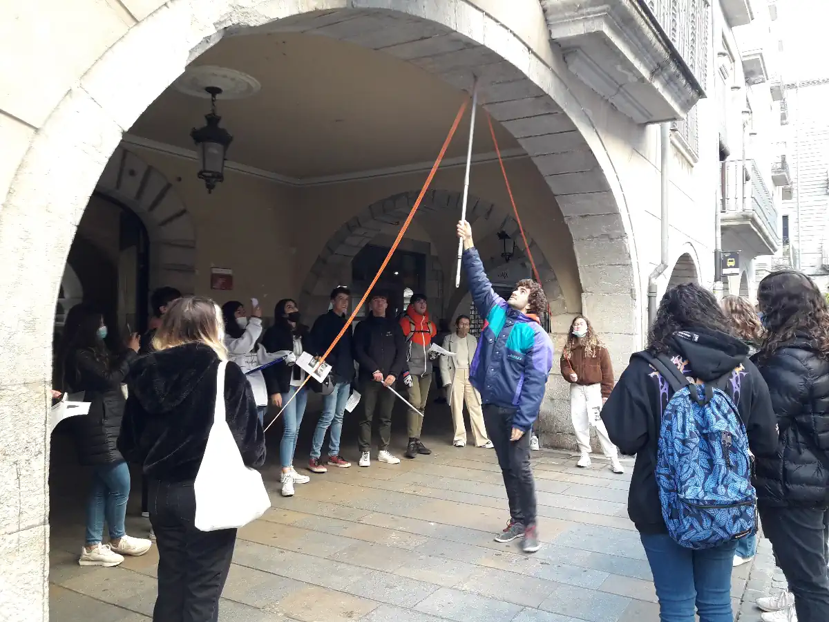 Estudiants a la Plaça del Vi analitzant un arc amb una corda