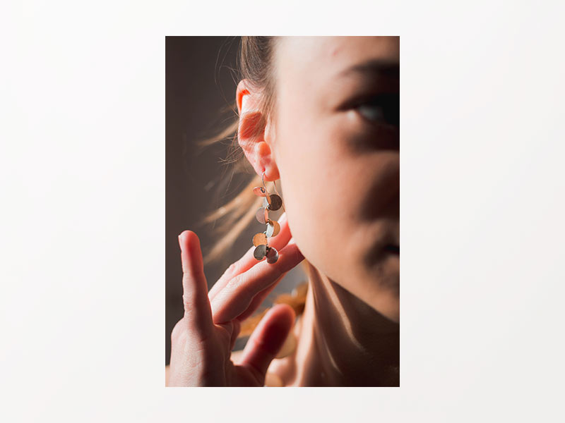 Primer pla d'una noia tocant-se les arrecades de l'orella dreta